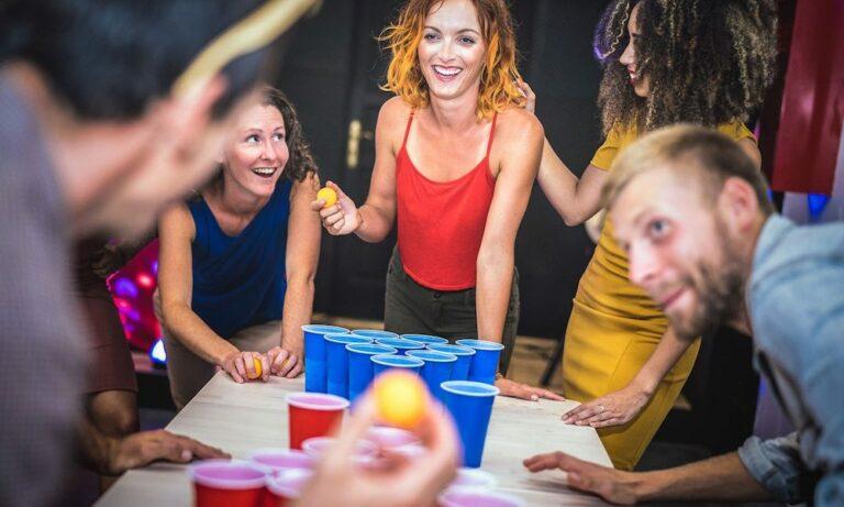 young adults playing beer pong