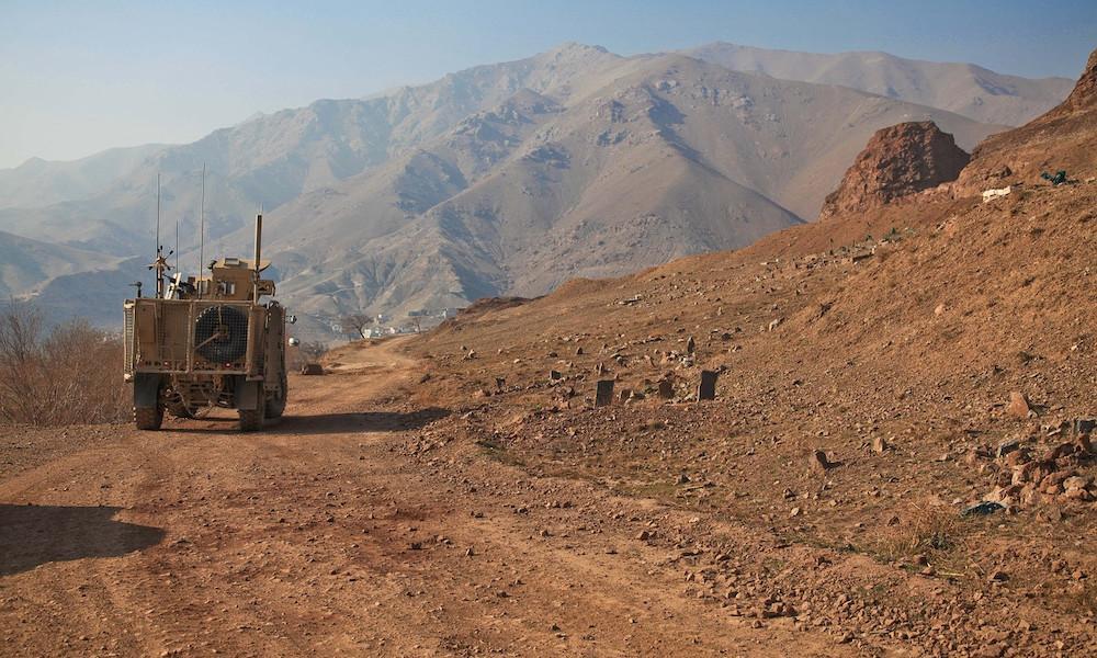 military vehicle driving across the desert