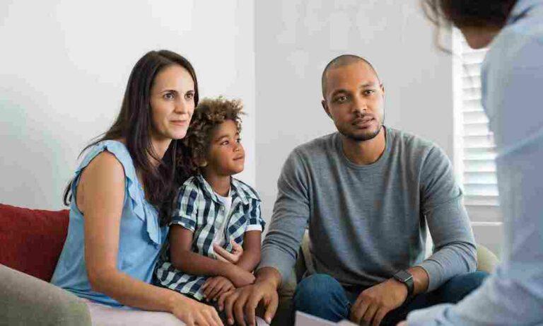 Parents with child on lap talking with counselor