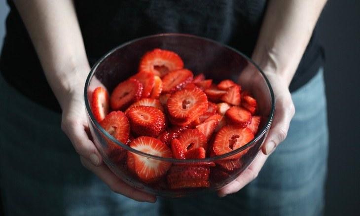 Image of person holding a bowl of strawberries