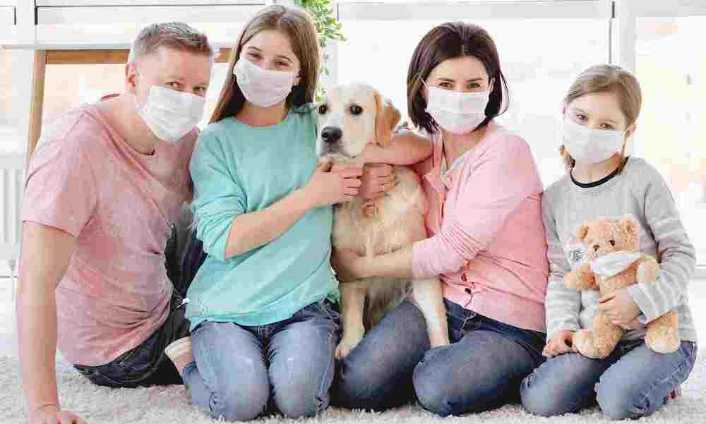family of four wearing masks, with their family dog