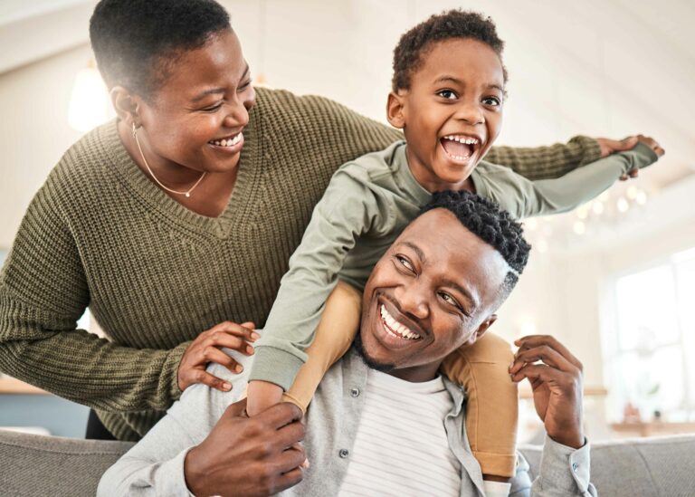 parents playing with their young child sitting on dad's shoulders