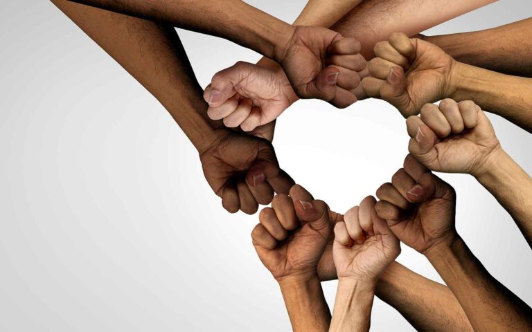 hands with various skin tones forming a circle with a heart at the center