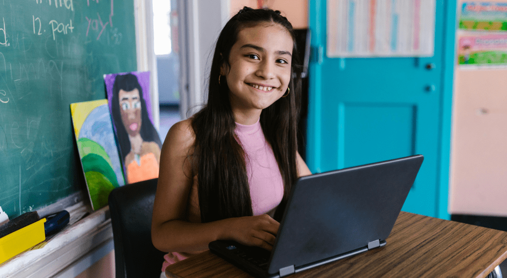 Smiling girl working on laptop