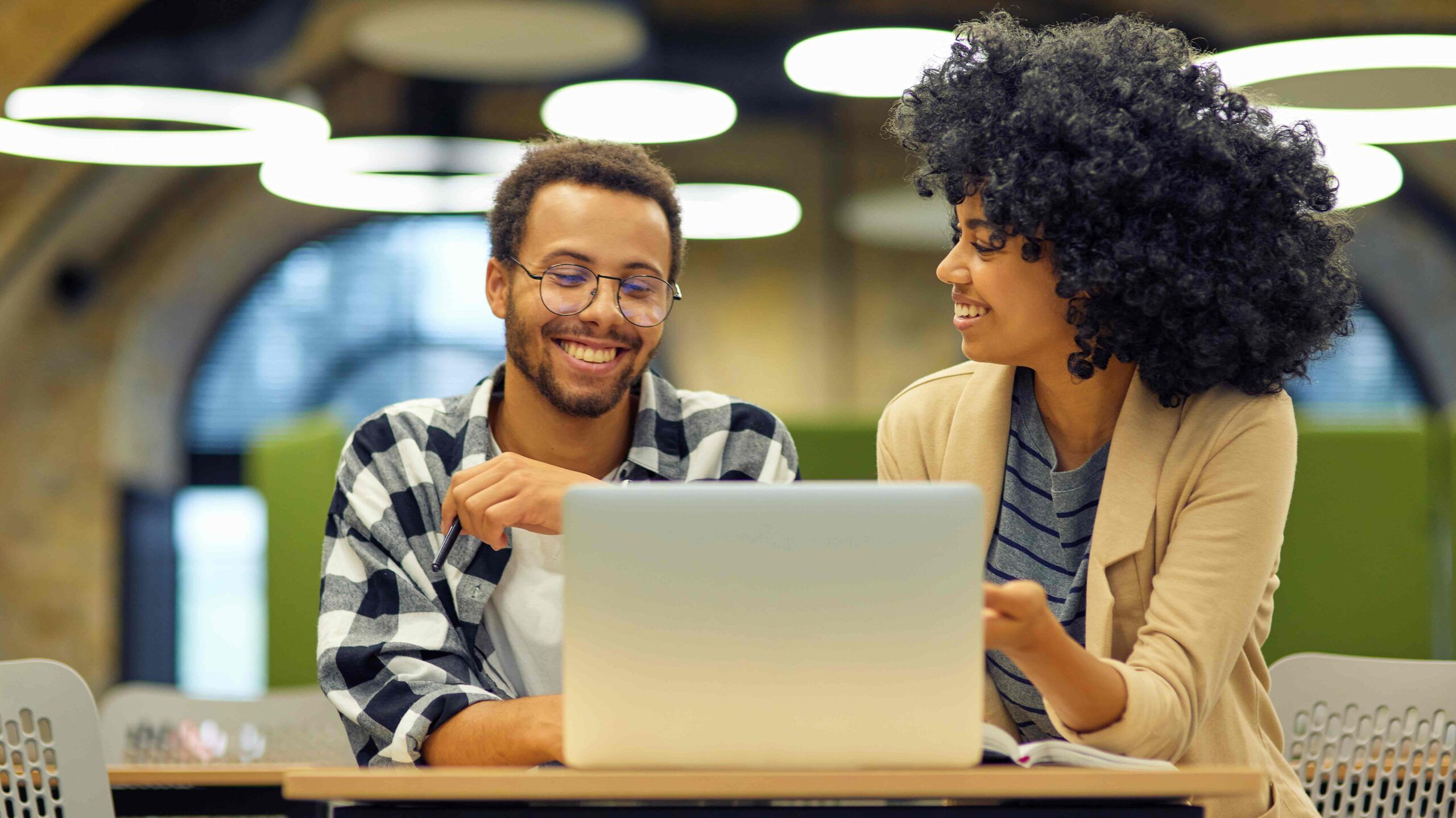 smiling man and woman working at a laptop together