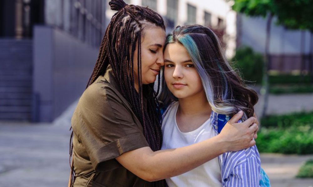 mom hugging her teen daughter